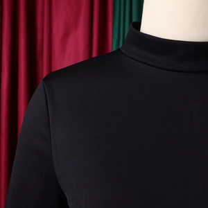 Close-up of the elegant high neck and textured shoulder stitching on the black dress