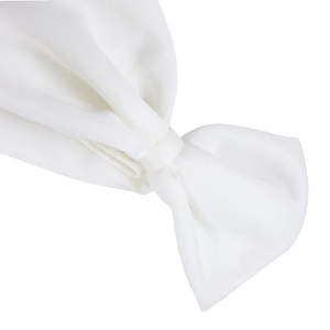 Close-up of the elegant bow detail on a white off-shoulder evening gown with matte texture