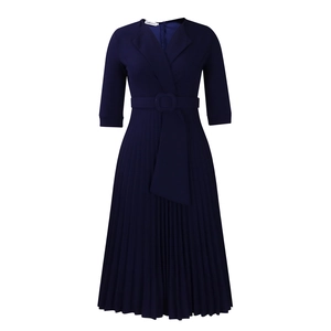 Détail de la robe bleu marine avec col tailleur, taille ceinturée et jupe plissée fluide