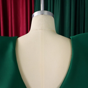 Detail of the V-neck back design on a dark green satin evening dress with fine stitching