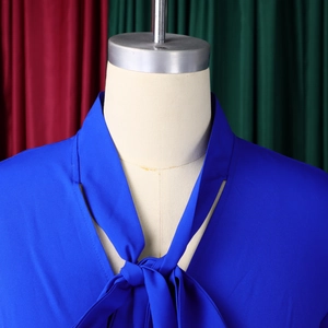 Detailed close-up of an elegant royal blue tie-neck blouse with soft chiffon texture