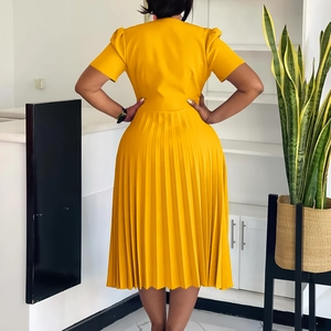 Rear view of vibrant yellow pleated dress showing fitted waist and elegant midi hem
