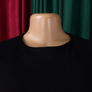 Close-up of the neat crew neck stitching and premium black fabric on a dress