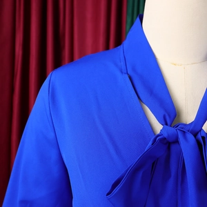 Detail of elegant royal blue V-neck top with stylish bow tie and pleated fabric texture