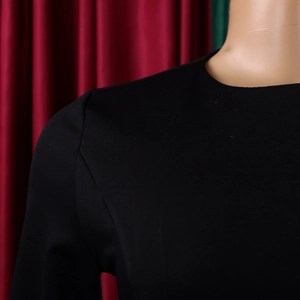 Detail of high-quality stitching on black crewneck dress with fine woven texture