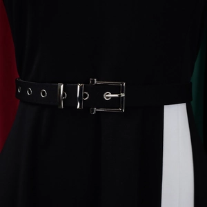 Detail of elegant black waist belt with silver buckle and metallic eyelets on dress