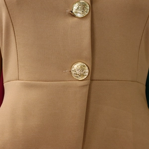 Close-up of camel slim-fit jacket showing refined texture and gold lion head buttons