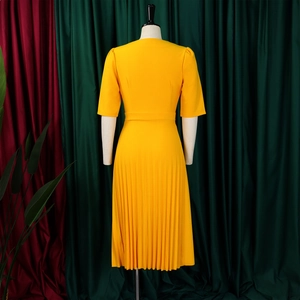 Detailed view of yellow V-neck dress featuring sunray pleats and fitted waistline