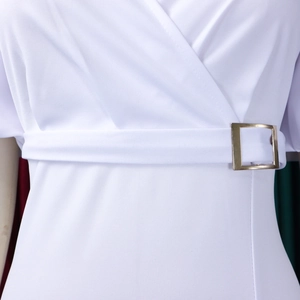 Detail des weißen Kleides mit V-Ausschnitt, Strukturstoff und goldener Gürtelschnalle