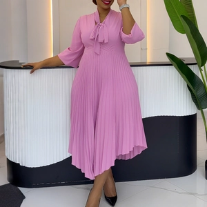 Detail of pink pleated dress featuring a V-neck bow tie and elegant flared sleeves