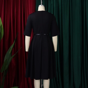 Vista posteriore dettagliata di un abito nero a trapezio con zip e cintura lucida sottile