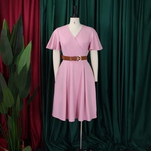 Detailed view of pink V-neck dress featuring flutter sleeves and a brown leather belt