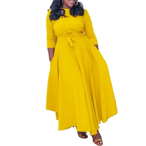 Detail of elegant yellow maxi dress showing belted waist and long sleeve design