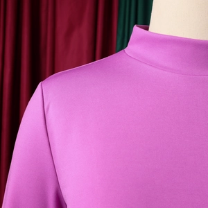 Detailed close-up of purple dress showing high neck collar and textured knit fabric