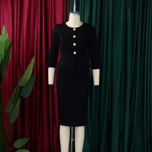 Close-up of black peplum top with embossed gold buttons and matching pencil skirt