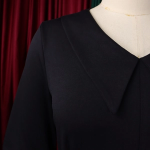 Dettaglio dello scollo a V e del tessuto a trama di questo elegante abito nero