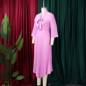 Detailed view of pink pleated chiffon dress with elegant pussy bow neckline