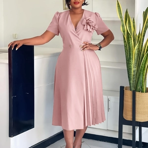 Detail of elegant V-neck pink dress featuring a side 3D flower and pleated skirt