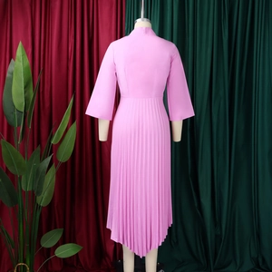 Back view of pink pleated dress with three-quarter sleeves and irregular hemline