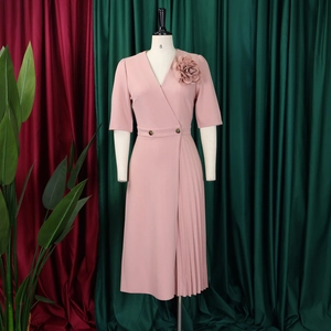 Detailed view of pink V-neck dress featuring 3D floral accent and golden double buttons
