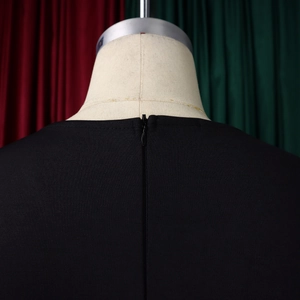 Dettaglio della cerniera invisibile sul retro di un elegante abito nero con texture