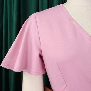 Detail view of pink V-neck dress featuring elegant ruffle flare sleeves and textured fabric
