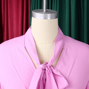 Detailed close-up of pink elegant V-neckline with a delicate self-tie bow design