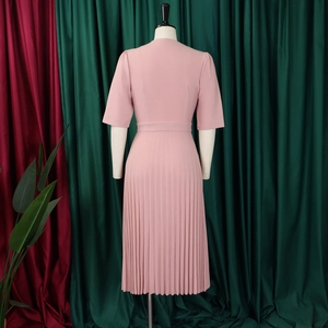 Detail view of the pleated skirt hem and cinched waist on the elegant mauve dress