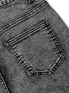 Close-up of vintage flower-embroidered jeans featuring washed denim and reinforced back pocket