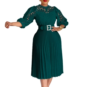 Detail view of dark green dress with intricate lace cutout bodice and pleated skirt