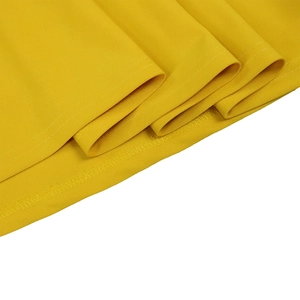 Detail of bright yellow dress hem showing neat single-needle stitching and overlock seams