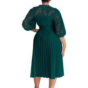 Detail of dark green lace bodice and pleated skirt with short puff sleeves on a dress