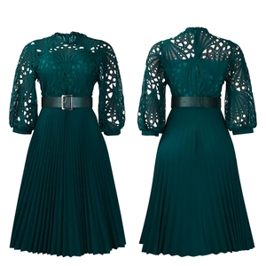 Detail of dark green lace hollow-out dress with pleated skirt and metallic belt