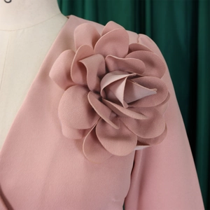 Detail of pink dress with a large 3D handmade floral applique on the shoulder part