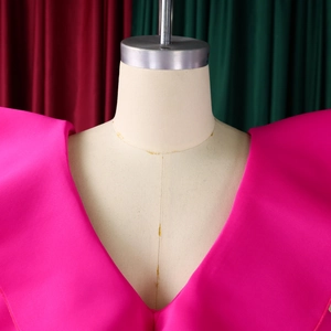 Detailed close-up of rose pink satin evening dress V-neckline on a female mannequin