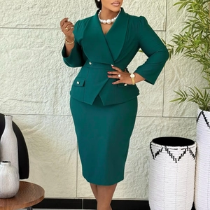 Close-up of dark green two-piece skirt suit with golden buttons and tailored waist