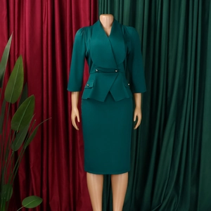 Close-up of elegant dark green business suit set with shawl collar jacket and midi skirt