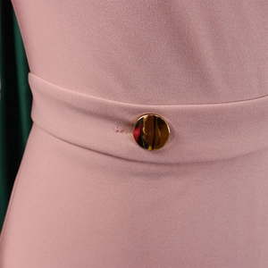 Close-up of waist pleated detail with a gold round button on pink elegant dress
