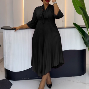 Detail of elegant black pleated skirt hem and waist tailoring of this midi dress