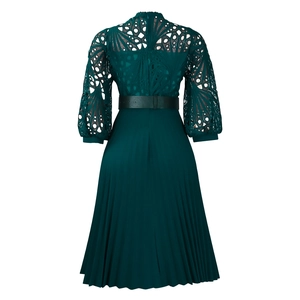 Detail of dark green lace hollow design and pleated skirt with elegant silk texture