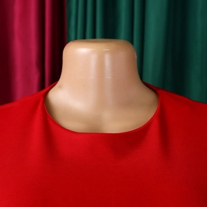 Close-up of the round neckline and textured red fabric on this elegant women's dress