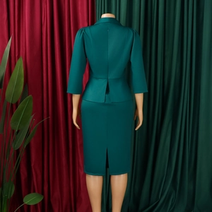 Detail of dark green two-piece set featuring suit lapels and midi pencil skirt