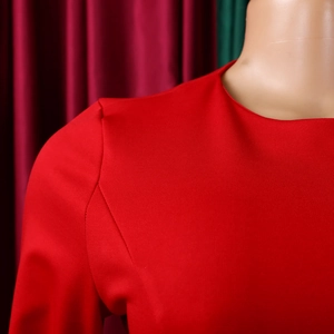 Detail of elegant red long sleeve dress with round neck and structured shoulder seams