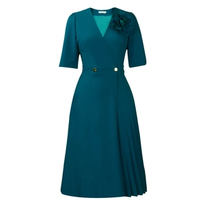 Detail of teal V-neck dress featuring 3D floral accent and gold buttons with pleats