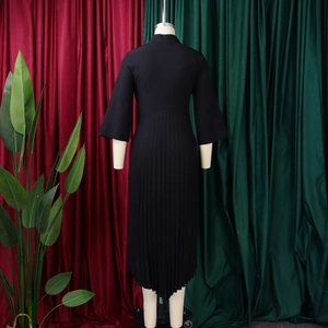 Detail of elegant black pleated skirt featuring an asymmetrical hem and textured fabric