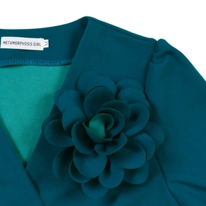 Detailed close-up of V-neck collar with large 3D floral decoration and brand label