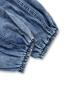Close-up of elastic ruffled cuffs on a vintage blue washed denim shirt with double stitching