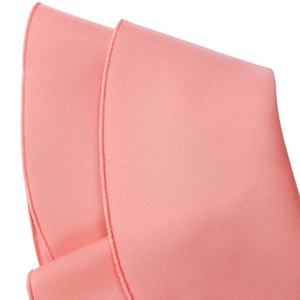 Macro view of coral pink fabric showing twill weave and professional overlock stitching detail