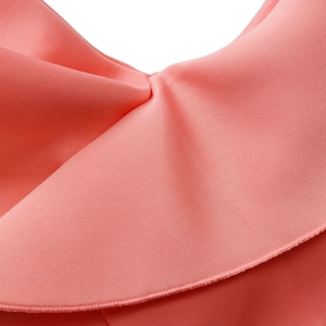Detail of coral pink V-neck dress showing high-elastic fabric and ruffle stitch quality