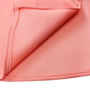 Detailed close-up of ruffle hem stitching and inner seam on pink v-neck fishtail dress